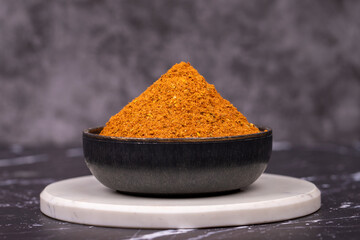 Cajun spice powder on dark background. Powdered dried cajun in bowl