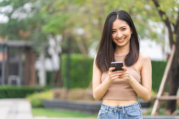 Happy feeling of beautiful Young woman using and text on smartphone. She shopping online. She smile very happy. Teenage girl reading news from mobile cell phone feeling excited.