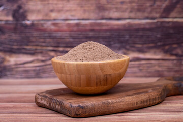 Allspice powder spice on wooden background. Powdered dried allspice in wooden bowl. Pimento spice,...