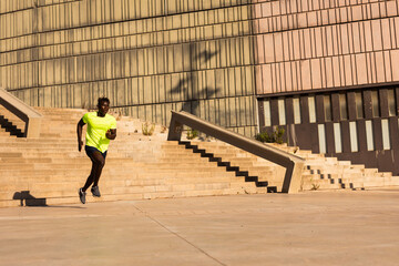 Fitness training outdoors. Handsome African man running. Muscular man training.