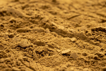 Pile of allspice powder as background, spice or seasoning as background. Close-up of Allspice powder in a wooden spoon. Pimento spice, Jamaican pepper and shavings