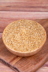 White sesame seeds on wooden background. Sesame seeds in wood bowl