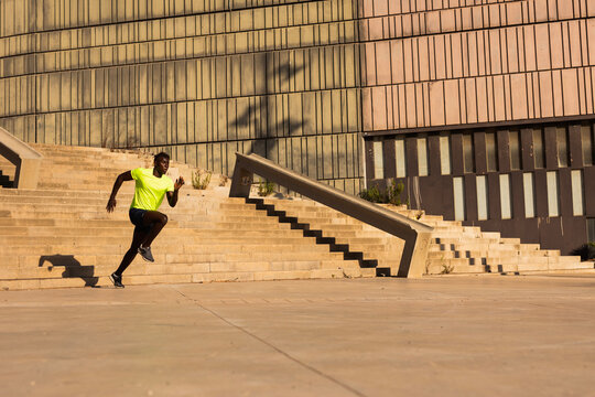 Fitness training outdoors. Handsome African man running. Muscular man training.