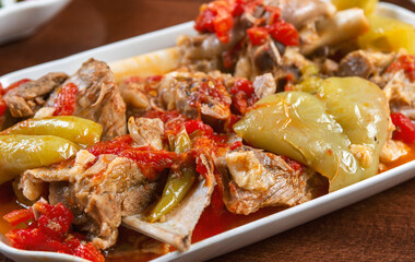 stewed lamb on the bone with vegetables on wooden desk.Khashlama is popular Armenian dish, which is prepared from beef with vegetables. Khashlama in the plate.  caucasian food