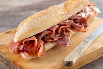 Spanish serrano ham sandwich on wooden table