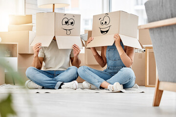 Funny, couple moving and boxes on head with faces, smile or emoji drawing on cardboard and new house, property or real estate. People, comic and box on body with happiness, crazy or joke in home