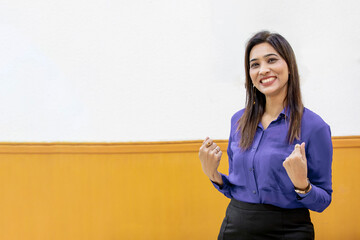 Young and confident corporate woman standing at office.