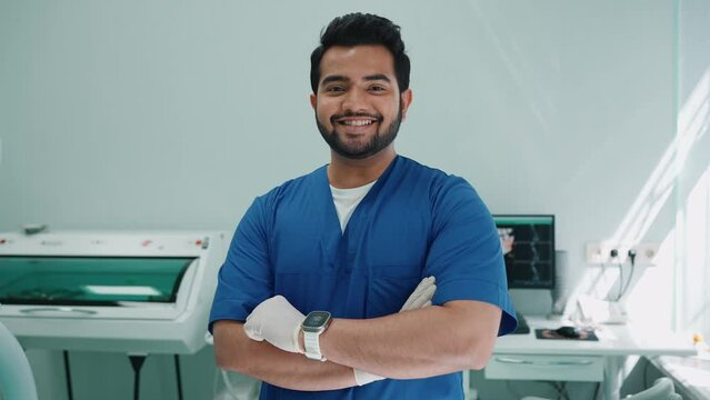 Happy indian male dentist looking at camera in hospital. Dentist appointment