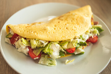 Homemade stuffed omelet with fresh vegetables and ham, with cottage cheese.