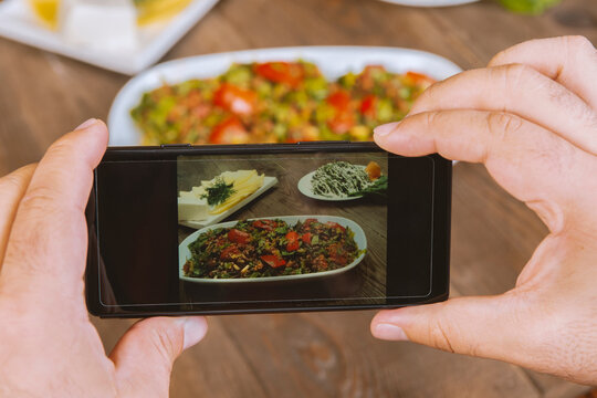 Food blogger using smartphone taking photo .Mans hands make phone photography of Oriental traditional meals. lunch or dinner. For social media, blogging.  Healthy food