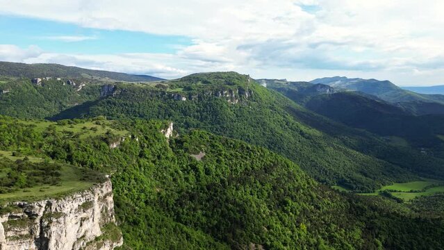 French countryside. Panoramic drone view of tree-covered hillsides of the heights of the Vercors, the marly hills and the valley Val de Drome, France