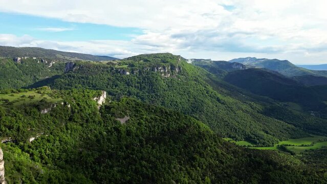 French countryside. Panoramic drone view of tree-covered hillsides of the heights of the Vercors, the marly hills and the valley Val de Drome, France