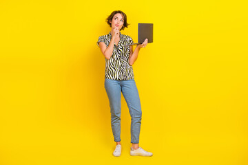 Full length photo of cute dreamy woman dressed zebra striped shirt typing modern gadget empty space isolated yellow color background