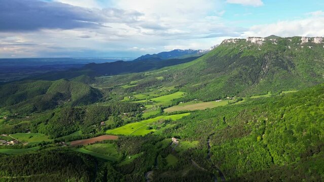 French countryside. Panoramic drone view of tree-covered hillsides of the heights of the Vercors, the marly hills and the valley Val de Drome, France