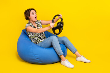 Full length photo of sweet shocked lady wear animal print shirt riding car looking empty space isolated yellow color background