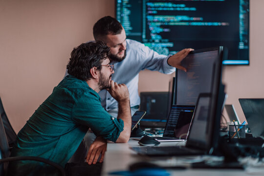 Programmers engrossed in deep collaboration, diligently working together to solve complex problems and develop innovative mobile applications with seamless functionality.