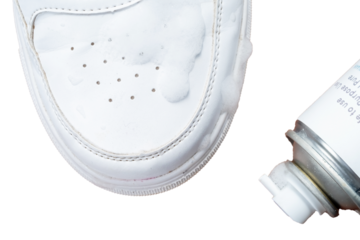 Leather white sneakers with a care kit. Leather footwear care concept