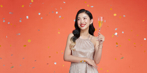 Charming happy girl in evening dress smiling and holding champagne glass - 608646945