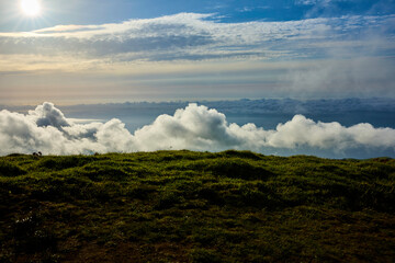 Wolken über einem grünen Hügel auf den Azoren