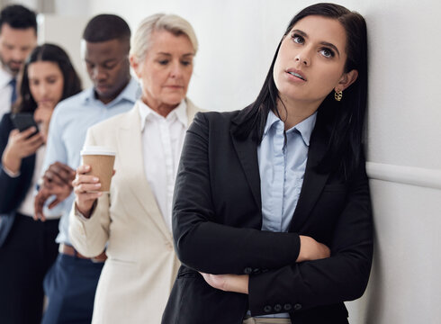 Tired, waiting room and woman in line for business interview, job application or hiring opportunity in corporate company. Group, people and frustrated person in queue, appointment and anxious time