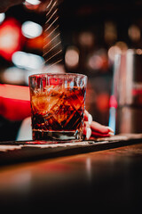 woman hand bartender making negroni cocktail in bar