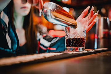 woman hand bartender making negroni cocktail in bar