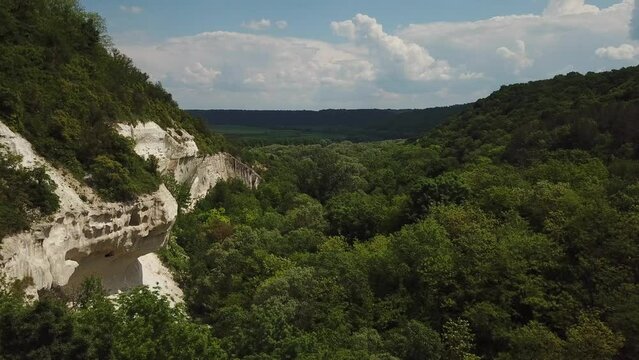 Aerial view of chalk rocks in forest. Drone footage.