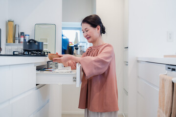 キッチンの収納を工夫するシニアの女性