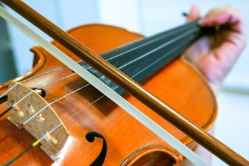 Primer plano de una alumna de violín tocando su instrumento en una clase de música.