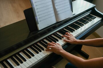 Alumna o profesora de piano tocando el instrumento donde se aprecia la digitación y close-up de sus manos.