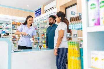 Medical pharmacy and healthcare providers concept. Professional Asian woman pharmacist recommending and selling medical product, medicine, drugs and supplements to patient customer in drugstore.