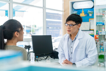 Asian man pharmacist medication recommendation about medicine, drugs and supplements to woman patient with stomach ache customer in drugstore. Medical pharmacy and healthcare providers concept.