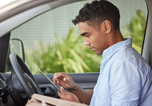 Delivery man in car with tablet, boxes and checking location, order list or online map for logistics. Courier service, driver in van and internet connection for digital logistic schedule with package