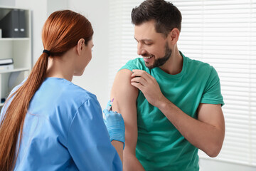 Doctor giving hepatitis vaccine to patient in clinic