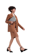 Beautiful happy businesswoman with laptop walking on white background