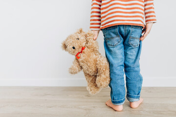little boy holding his best friend teddy bear indoor