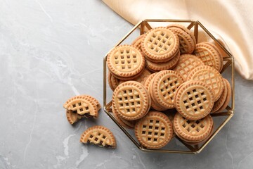 Tasty sandwich cookies with cream on grey table, flat lay. Space for text
