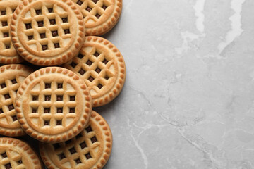 Tasty sandwich cookies with cream on grey table, flat lay. Space for text