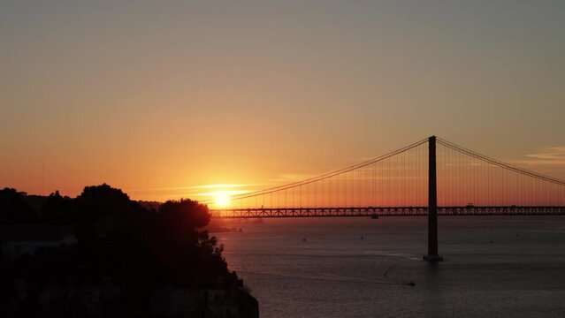 Bright orange sunset over the bridge and a river