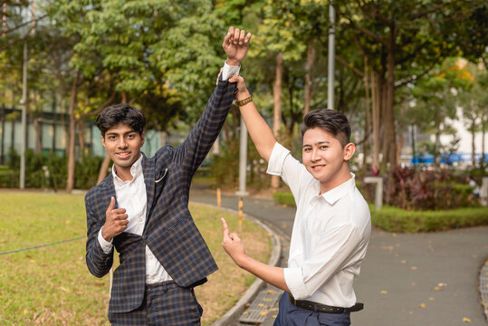 An asian guy champions and endorses his fellow office mate or teammate. A young man vouched by his colleague and supporter.