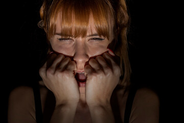 Portrait of scared woman of something in the dark. Closed eyes