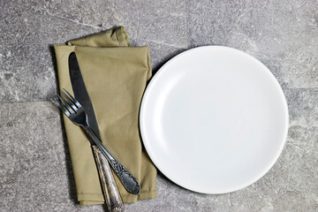Festive fashion table setting. empty white plate with knife and fork, napkin. The distribution of guests in places at the festive table
