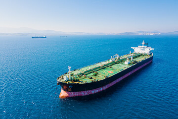 Aerial view of crude oil tanker anchored nearby cargo port, waiting for the uploading process