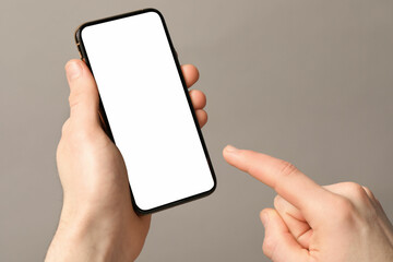 Man holding smartphone with blank screen on light grey background, closeup. Mockup for design