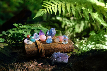 witch spell book and gemstones on natural blurred forest background. Minerals for healing Magic Crystal Ritual, Witchcraft. Reiki therapy. spiritual esoteric practice for harmony soul, life balance - obrazy, fototapety, plakaty
