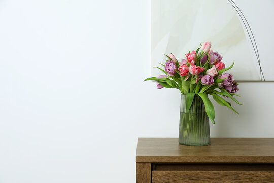 Beautiful bouquet of colorful tulip flowers on wooden table indoors. Space for text