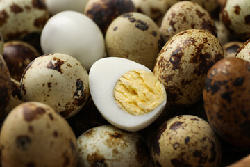 Heap of unpeeled and peeled hard boiled quail eggs as background, closeup