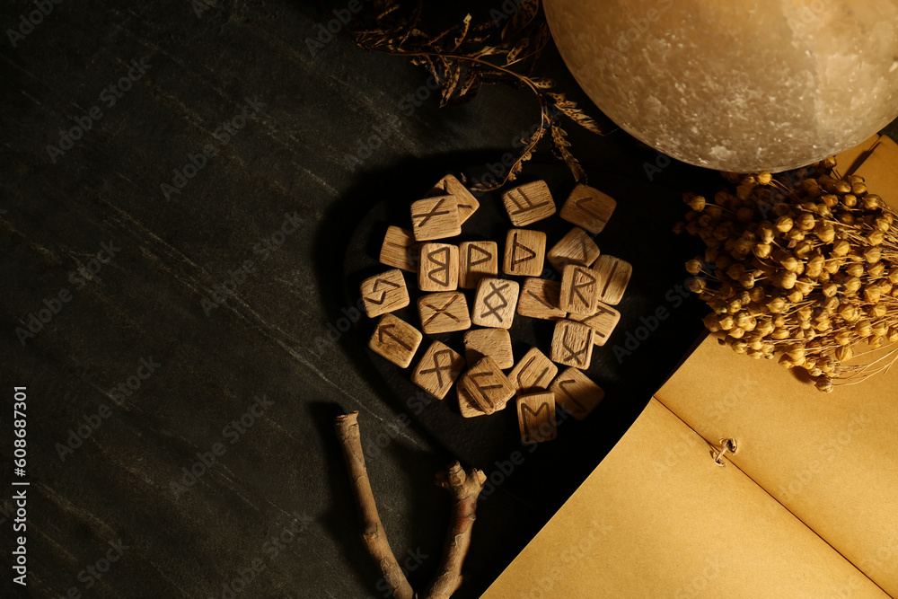 Canvas Prints wooden runes and dried flowers on black marble table, flat lay. space for text