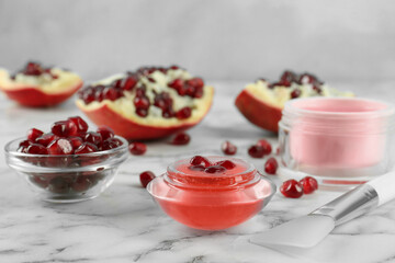 Homemade cosmetic products and fresh pomegranate on white marble table. DIY beauty recipe