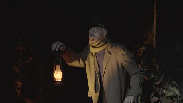 This video shows an animatronic old timer frightened man holding a lantern in the dark.